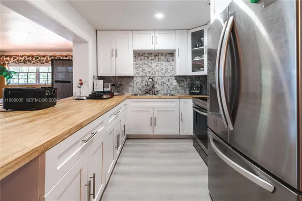 a view of a hallway with wooden floor and a bathroom