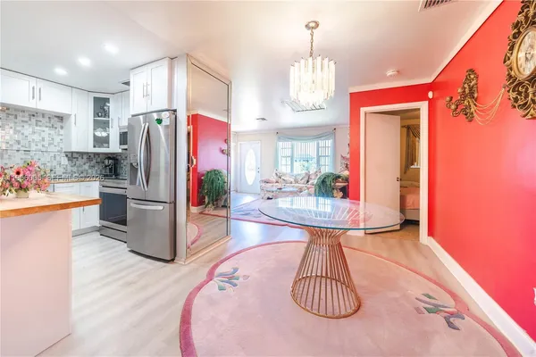 a kitchen with stainless steel appliances a dining table a sink and a refrigerator