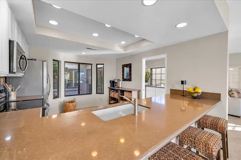 a kitchen with stainless steel appliances granite countertop a refrigerator a sink a stove a microwave and island