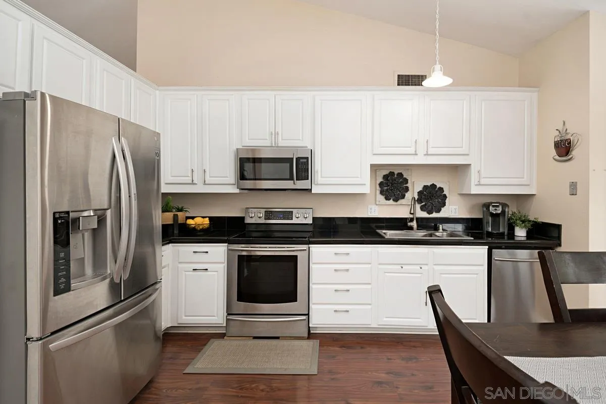 11068 Pinzon Way San Diego, CA 92127 - Photo 11 of 31 a kitchen with stainless steel appliances a stove a sink cabinets and a refrigerator