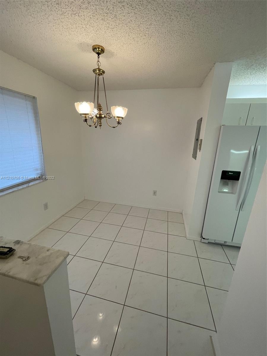 9599 Weldon Circle, Unit A304 Tamarac, FL 33321 - Photo 11 of 12 a view of a livingroom with a chandelier fan and fire place