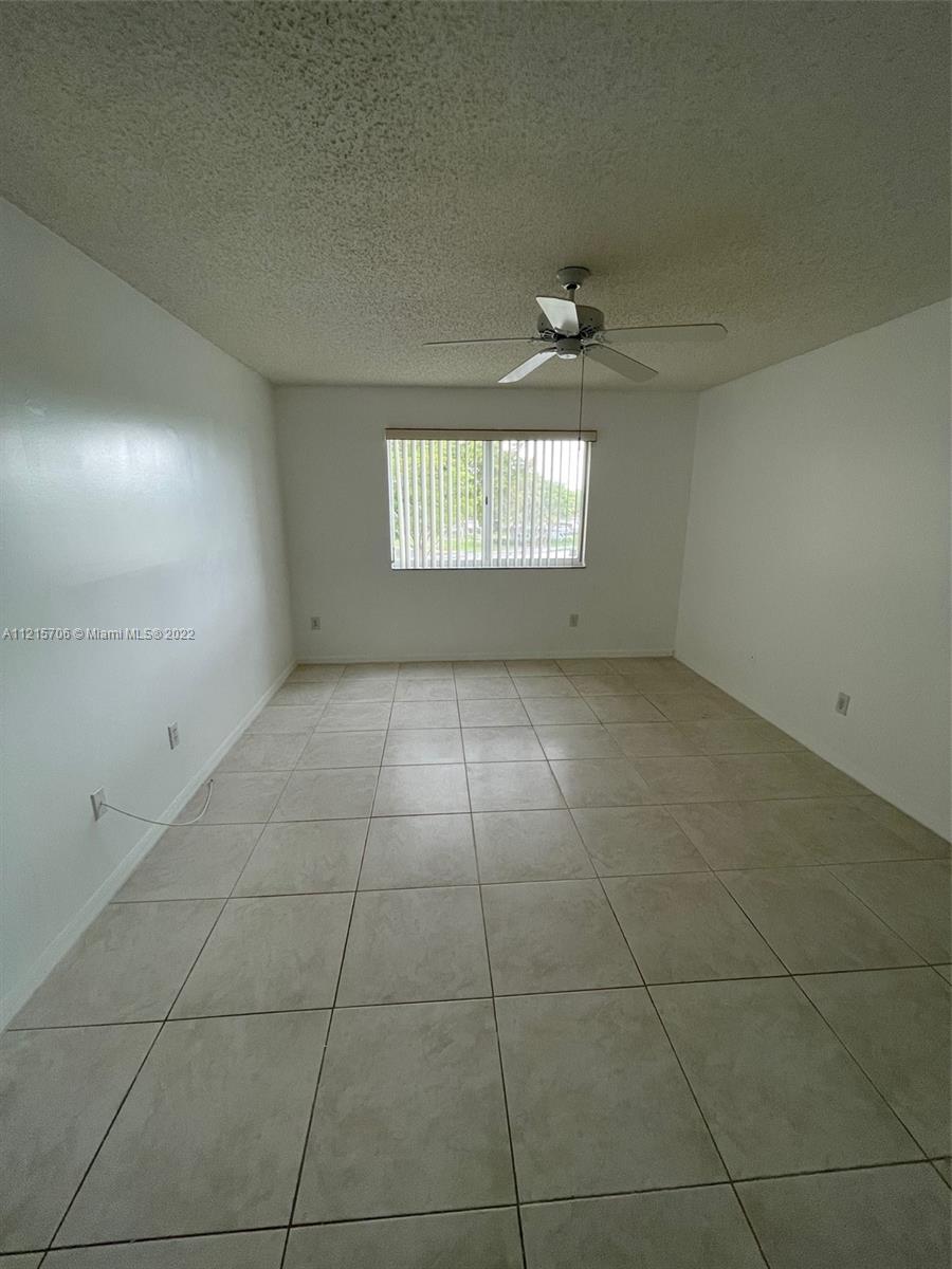 9599 Weldon Circle, Unit A304 Tamarac, FL 33321 - Photo 2 of 12 an empty room with windows and entrance