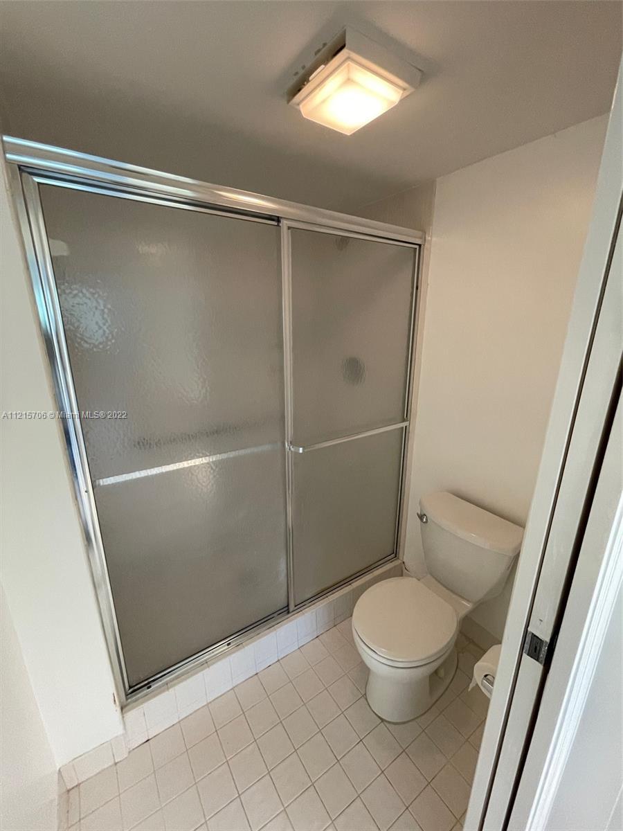 9599 Weldon Circle, Unit A304 Tamarac, FL 33321 - Photo 5 of 12 a bathroom with a granite countertop toilet and a shower