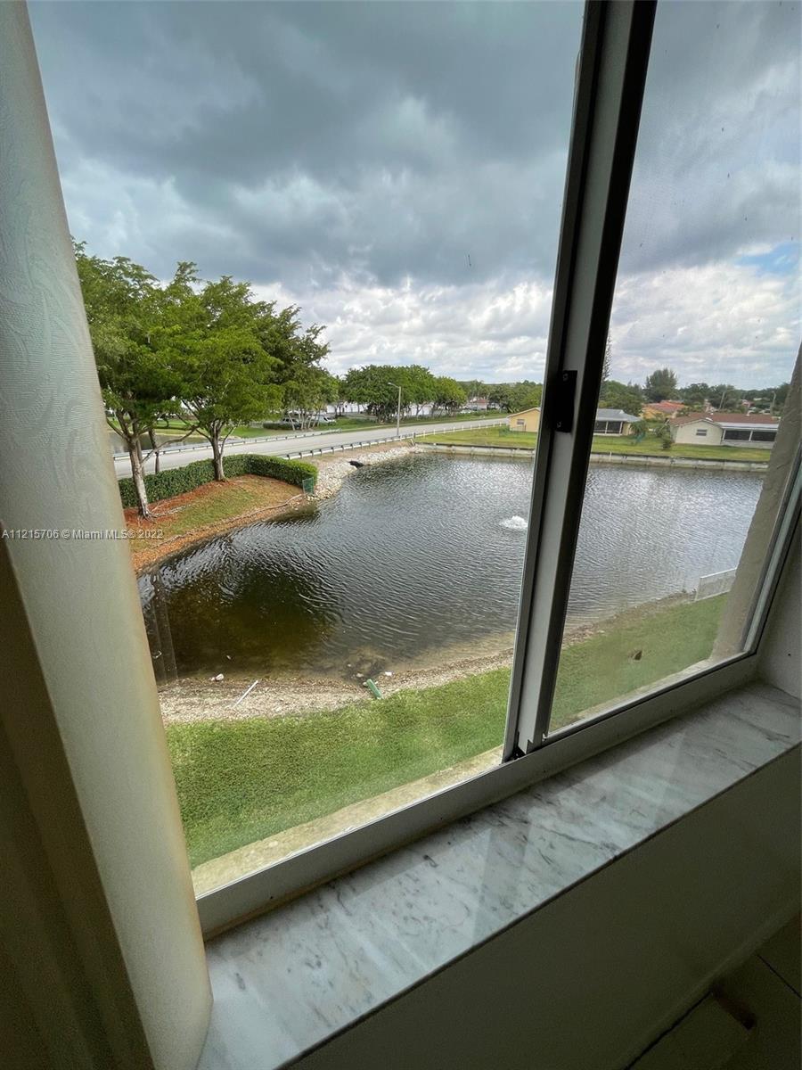 9599 Weldon Circle, Unit A304 Tamarac, FL 33321 - Photo 6 of 12 a view of a lake from a window