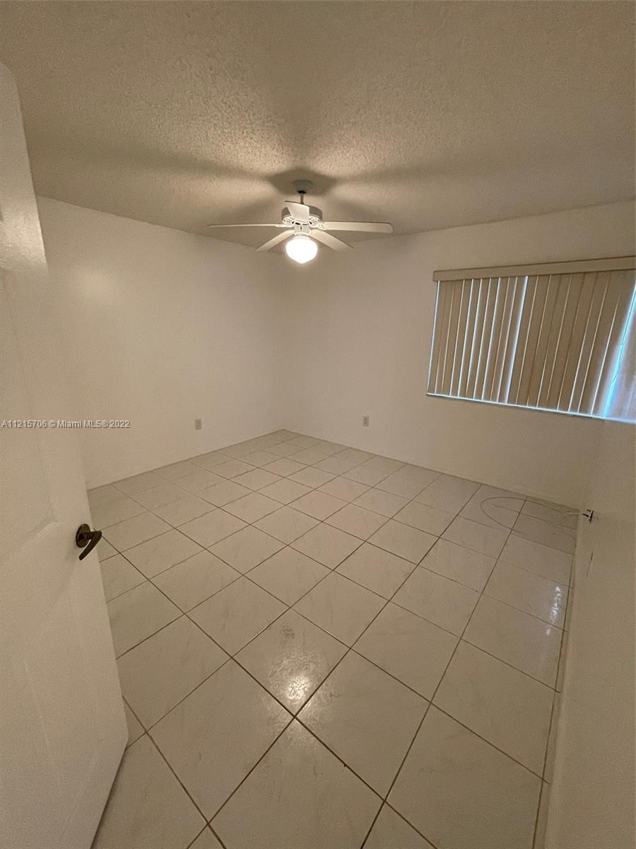 9599 Weldon Circle, Unit A304 Tamarac, FL 33321 - Photo 10 of 12 an empty room with windows and fan
