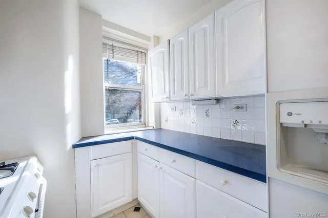 a kitchen with granite countertop white cabinets and a window