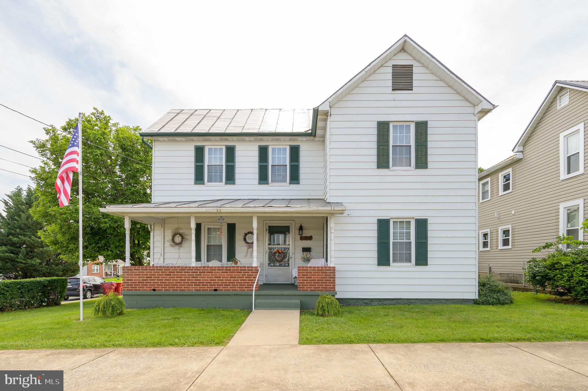 a front view of a house with a garden and yard