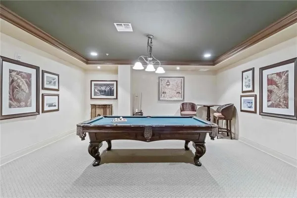 a room with furniture pool table and window