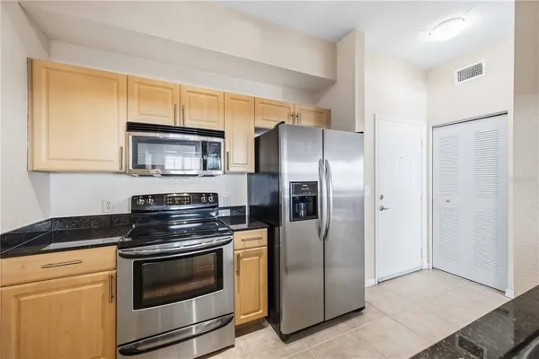 a kitchen with stainless steel appliances granite countertop a refrigerator stove and microwave