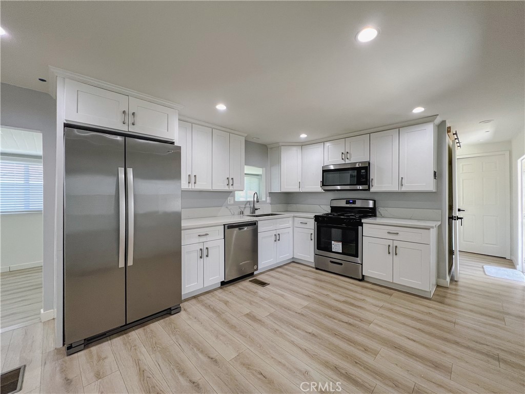 1245 West Cienega Avenue San Dimas, CA 91773 - Photo 2 of 14 a kitchen with a refrigerator a sink and cabinets