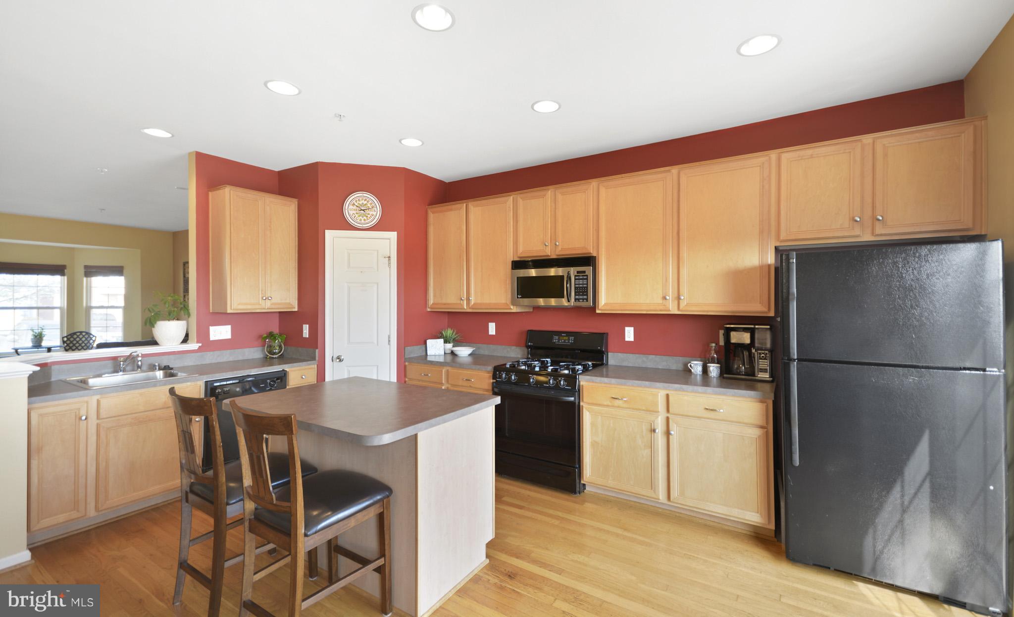 1741 Trestle Street Mount Airy, MD 21771 - Photo 12 of 30 a kitchen with a refrigerator a stove top oven a sink dishwasher and white cabinets with wooden floor
