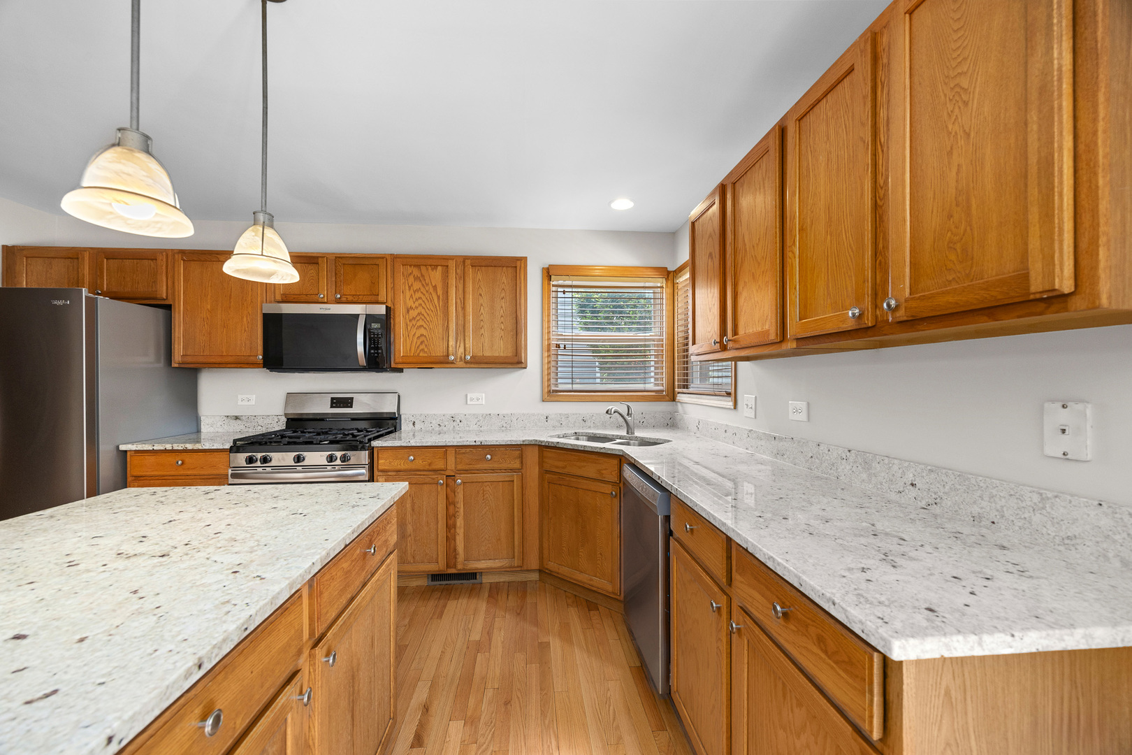 1301 Bridgehampton Drive Plainfield, IL 60586 - Photo 11 of 34 a kitchen with stainless steel appliances granite countertop wooden cabinets a sink and dishwasher