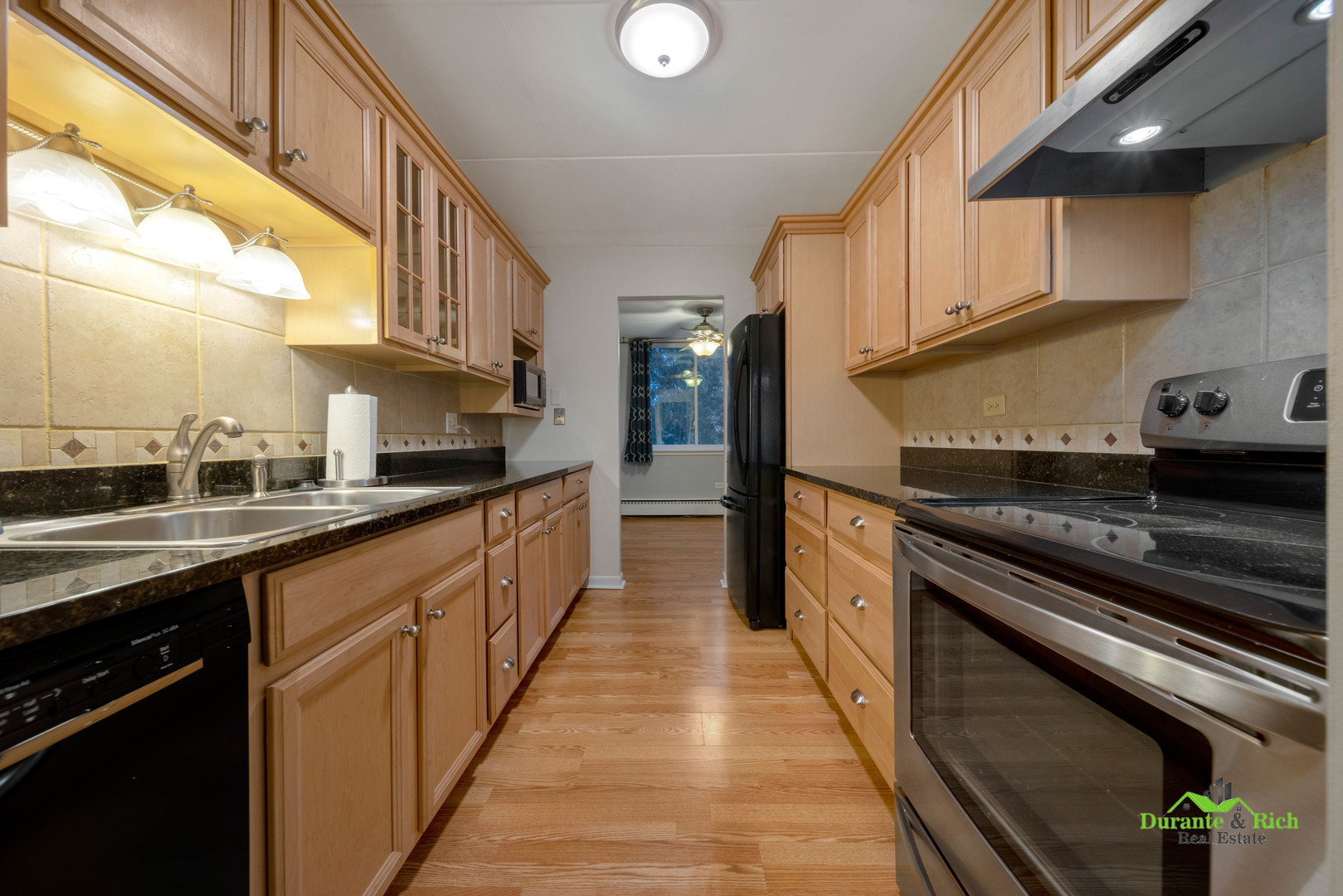 225 South Rohlwing Road, Unit 118 Palatine, IL 60074 - Photo 6 of 12 a large kitchen with stainless steel appliances granite countertop a stove and a sink