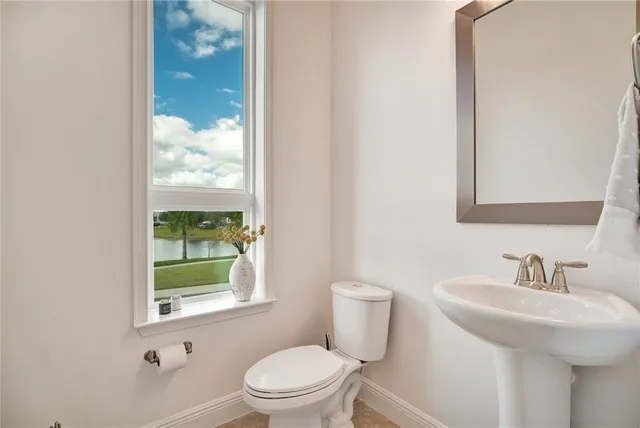 a bathroom with a toilet a sink and a window