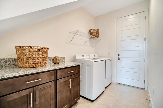 a utility room with cabinets washer and dryer