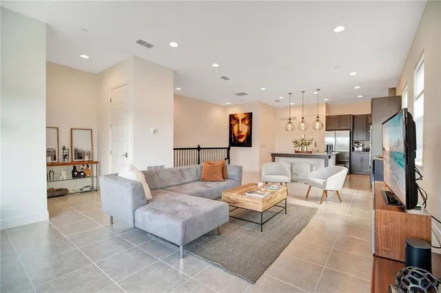 a living room with furniture and a view of kitchen