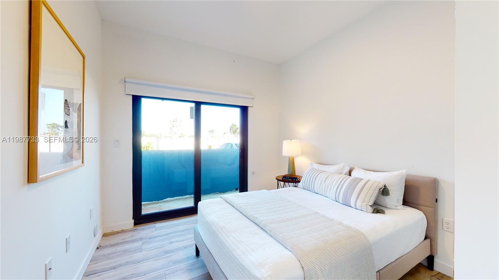 24705 Southwest 129th Avenue, Unit 108 Homestead, FL 33032 - Photo 20 of 33 a bedroom with a balcony and wooden floor
