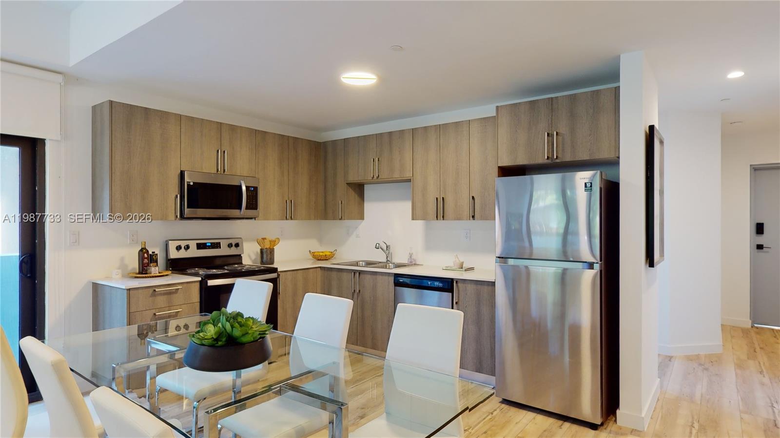 24705 Southwest 129th Avenue, Unit 108 Homestead, FL 33032 - Photo 5 of 33 a kitchen with stainless steel appliances a refrigerator stove microwave and cabinets