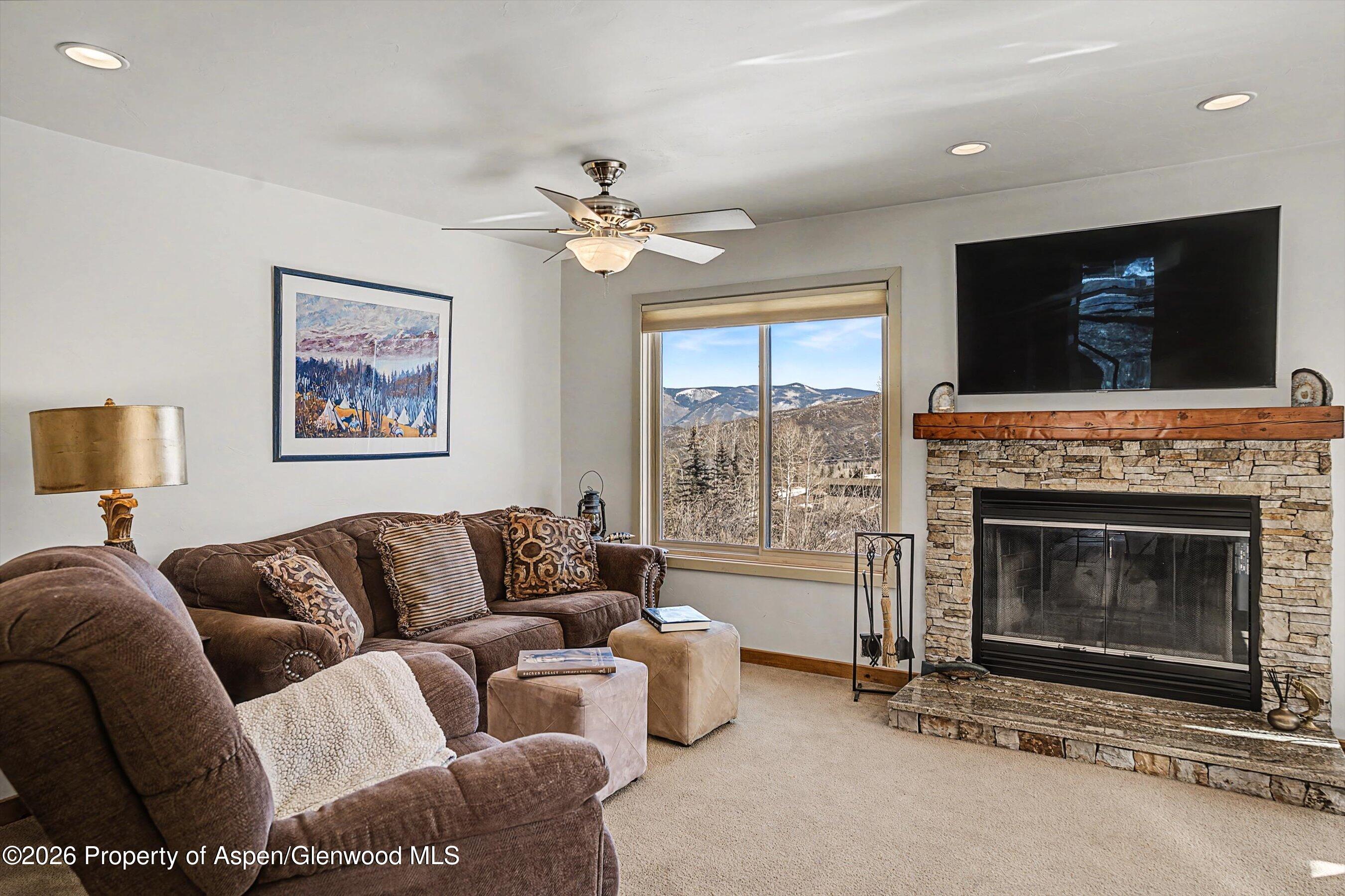 34 Lower Woodbridge Road, Unit 149 Snowmass Village, CO 81615 - Photo 3 of 15 a living room with furniture a flat screen tv and a fireplace