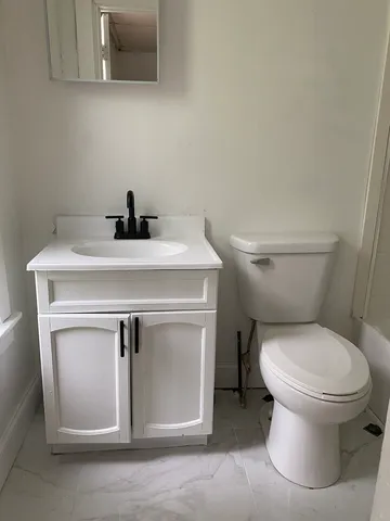 a bathroom with a toilet sink and mirror