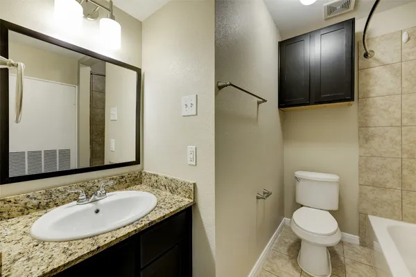 a bathroom with a granite countertop sink toilet and shower