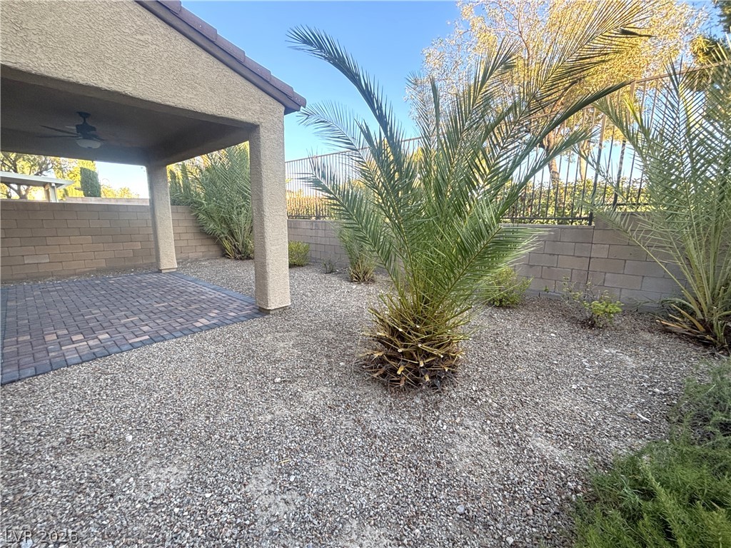 121 Elm Reed Avenue Las Vegas, NV 89113 - Photo 30 of 30 A well-appointed patio with brick pavers offers a delightful outdoor retreat, framed by mature palm trees.