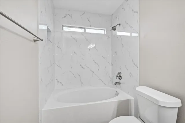 a white bath tub sitting next to a white toilet