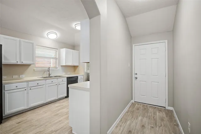 a kitchen with cabinets stove and a wooden floor