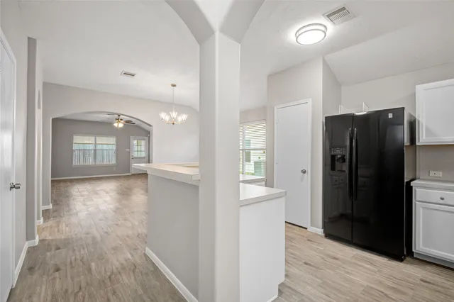 a view of a hallway with wooden floor and a cabinet