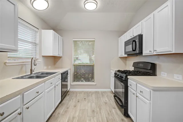 a kitchen with a stove a sink and a microwave