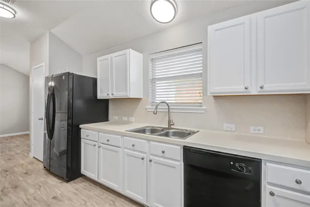 a kitchen with a sink cabinets and a refrigerator