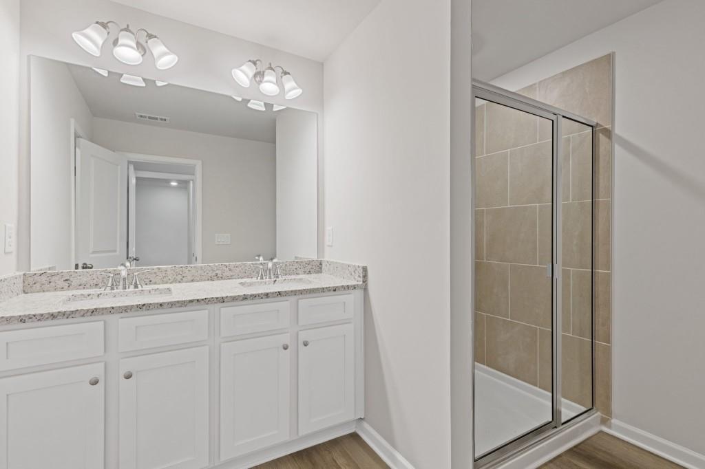939 Elwood Street Dacula, GA 30019 - Photo 5 of 22 a bathroom with a granite countertop sink and a mirror