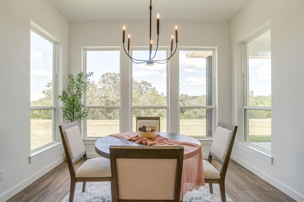 9012 Valley Oak Court Springtown, TX 76082 - Photo 19 of 40 a view of a dining room with furniture a chandelier and wooden floor