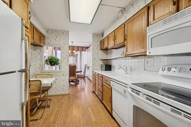 a kitchen with stainless steel appliances a sink a stove top oven a counter space and cabinets