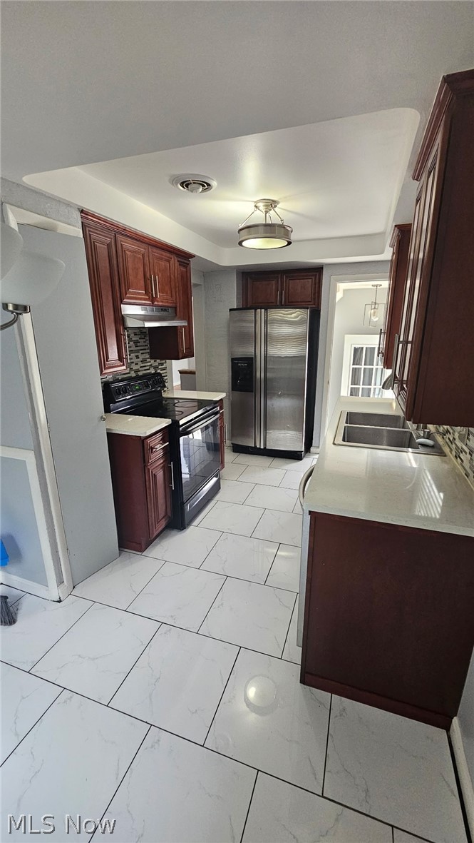 4237 Stonehaven Road South Euclid, OH 44121 - Photo 19 of 35 Kitchen featuring dark wood-finish cabinetry, white countertops, tile backsplash, stainless steel appliances, and white tile flooring