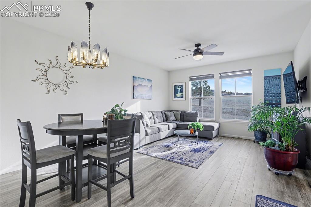 17063 Blue Mist Grove Monument, CO 80132 - Photo 6 of 33 a living room with furniture and a chandelier