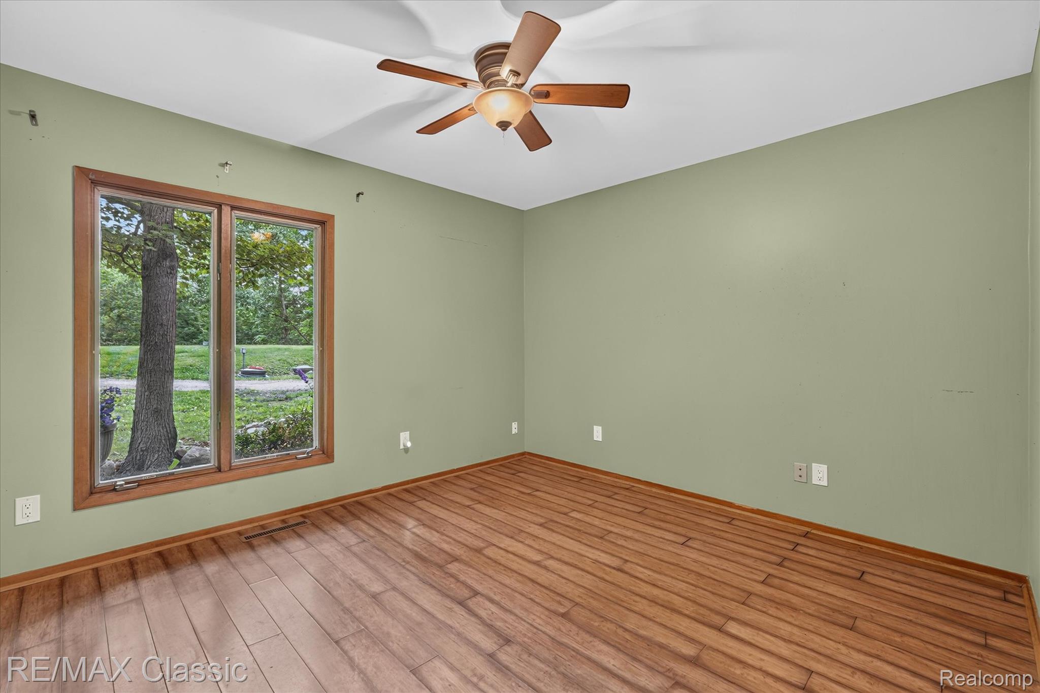 12189 Gage Road Holly, MI 48442 - Photo 25 of 69 Room featuring wood-finish flooring, a ceiling fan with integrated lighting, and a large window with wood trim