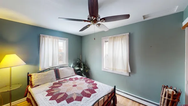 a bedroom with a bed mirror on dresser and a chandelier