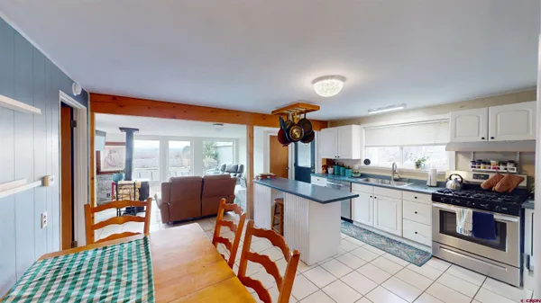a kitchen with stainless steel appliances granite countertop a stove top oven a sink dishwasher and white cabinets with wooden floor