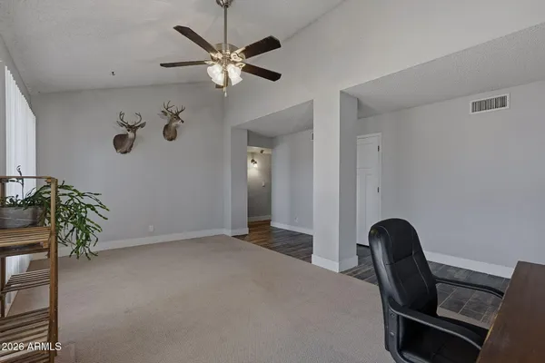a bedroom with a bed a flat screen tv and a chandelier