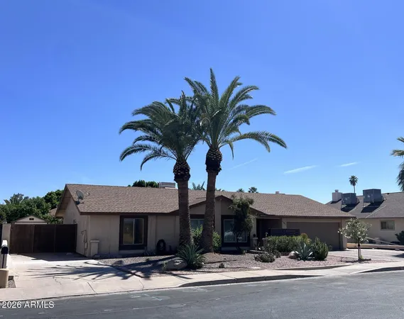a front view of a house with yard and parking