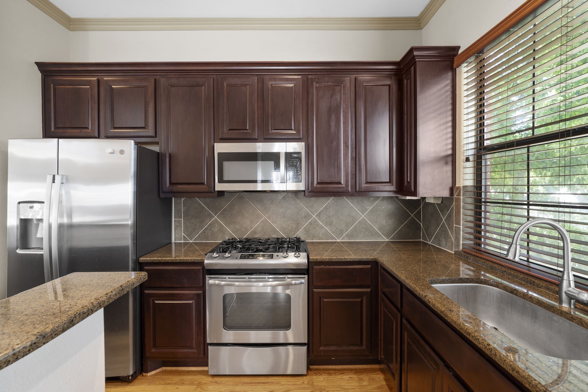 1218 Sandman Street Houston, TX 77007 - Photo 17 of 38 a kitchen with granite countertop a sink stove and refrigerator