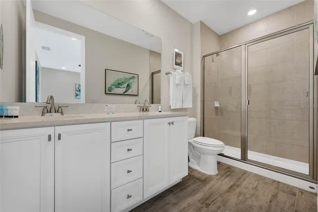 a bathroom with a double vanity sink toilet and shower