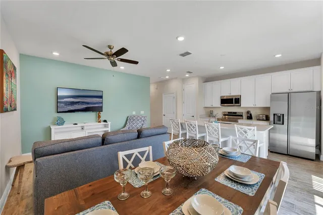 a living room with furniture kitchen view and a wooden floor