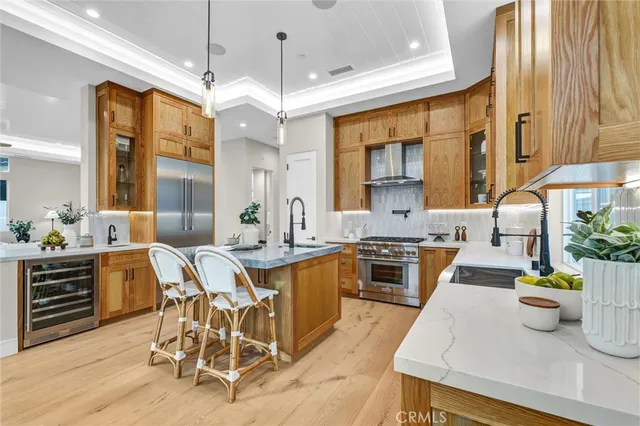 a kitchen with stainless steel appliances granite countertop a stove top oven a sink a dining table and chairs with wooden floor