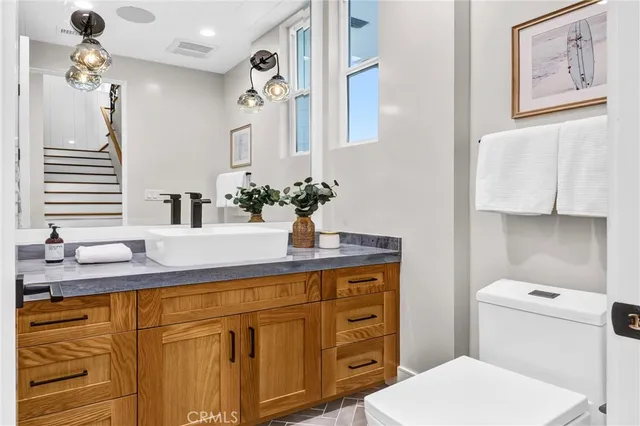 a bathroom with a granite countertop sink mirror vanity and toilet