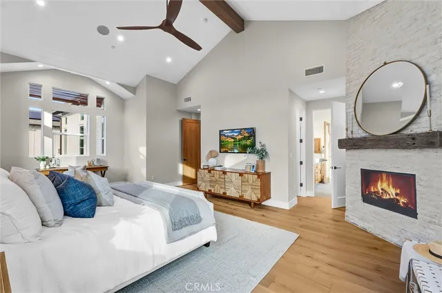 a spacious bedroom with a bed a fireplace and a chandelier