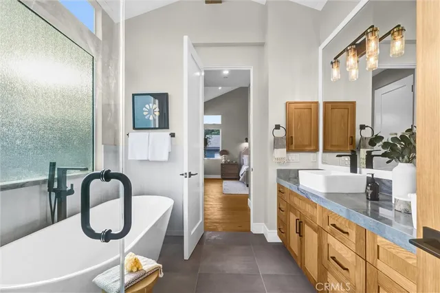 a large bathroom with a granite countertop tub and a large mirror