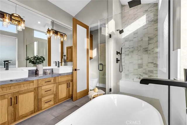 a bathroom with a double vanity sink a large mirror a bathtub and shower