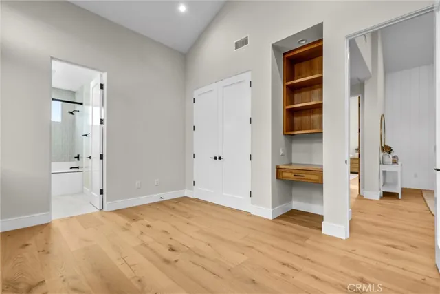a view of empty room with wooden floor and cabinet